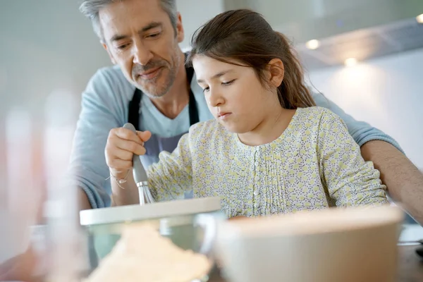 Daddy with daughter baking cake