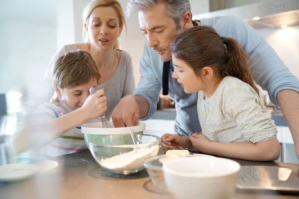 Ouders met kinderen bakken taart — Stockfoto