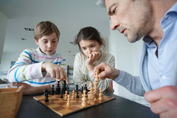 Family playing chess game