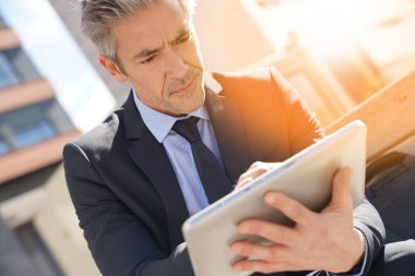 Dijital tablet üzerinde çalışan iş adamı
