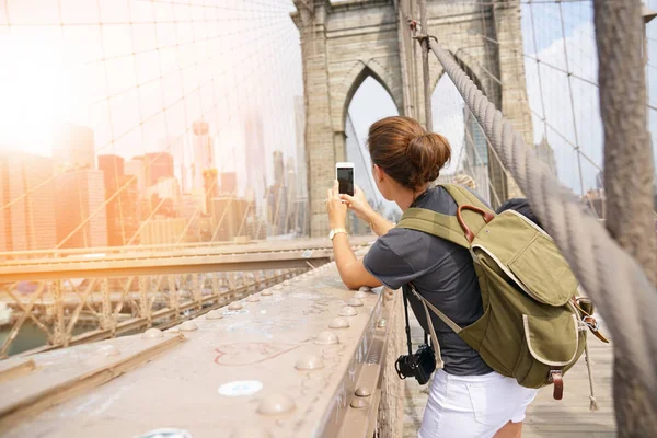 Tourist on Brooklyn bridge taking picture — Stock Photo, Image