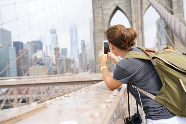 Tourist on Brooklyn bridge taking picture — Stock Photo, Image