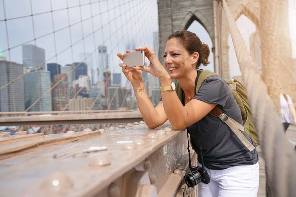 Tourist on Brooklyn bridge taking picture — Stock Photo, Image