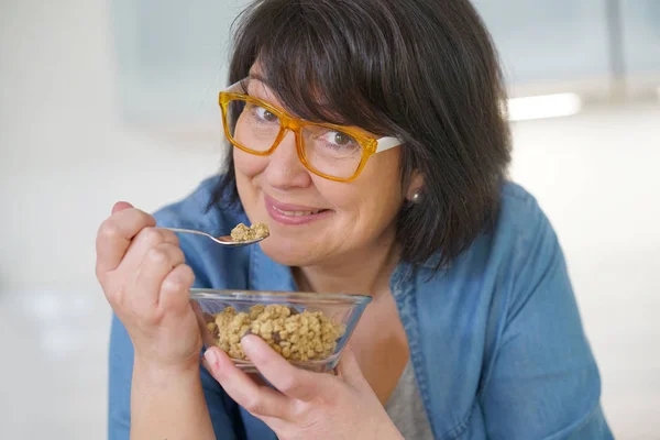 Woman in kitchen eating cereals — Stock Photo, Image