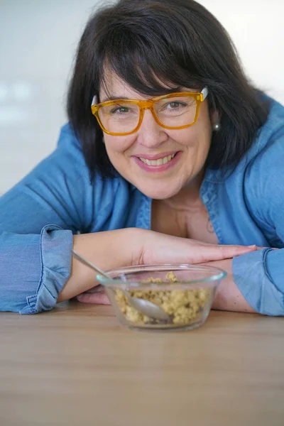 Mulher na cozinha comer cereais — Fotografia de Stock