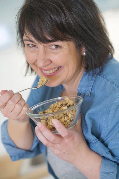 Γυναίκα στην κουζίνα, τρώγοντας δημητριακά — Φωτογραφία Αρχείου