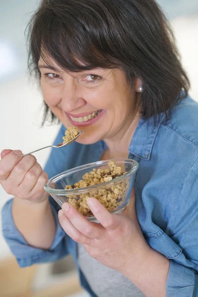 Frau in Küche isst Müsli — Stockfoto