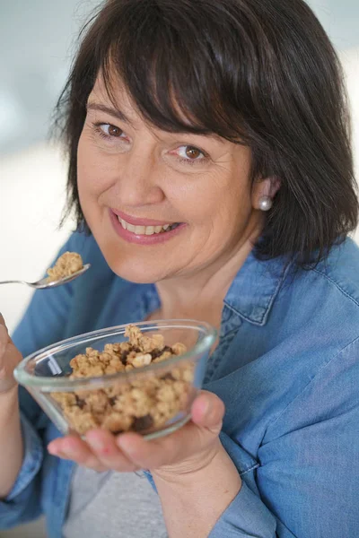 Mulher na cozinha comer cereais — Fotografia de Stock