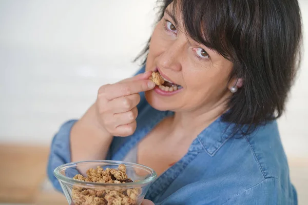 Mulher na cozinha comer cereais — Fotografia de Stock