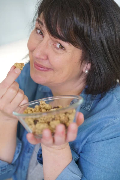 Woman in kitchen eating cereals — Stock Photo, Image