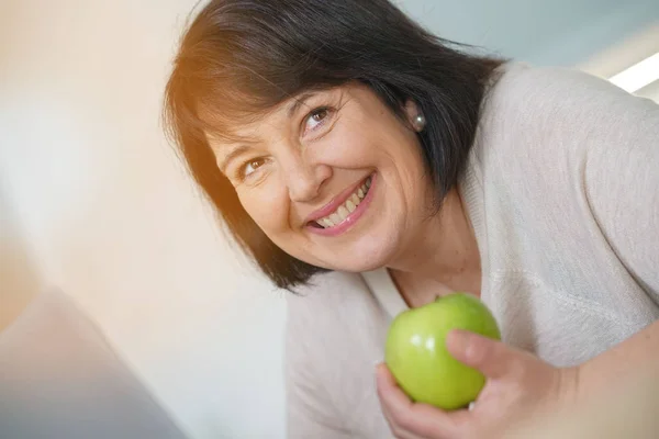 Mulher comendo maçã verde — Fotografia de Stock