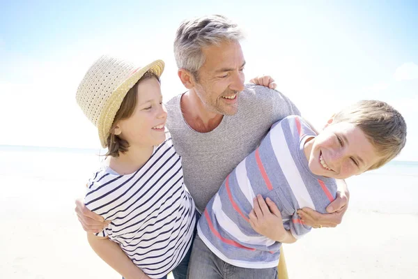Vader met kinderen op het strand — Stockfoto