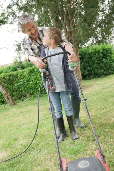 Otec a syn sekají trávník — Stock fotografie
