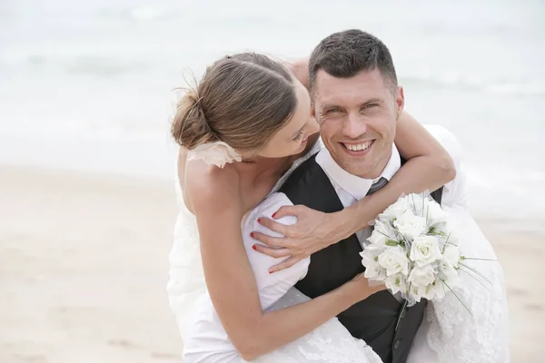 Groom giving piggyback ride to bride — Stock Photo, Image