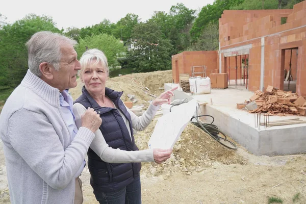 Couple in building site checking plans — Stock Photo, Image