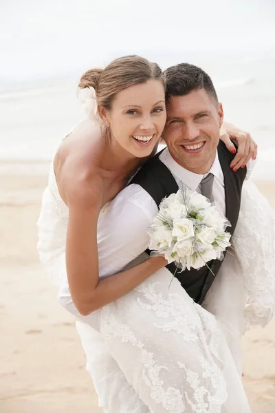 Groom dando passeio de piggyback para noiva — Fotografia de Stock