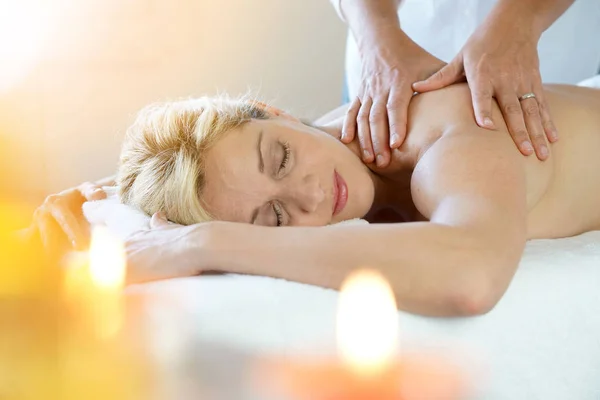 Mulher que coloca na mesa de massagem — Fotografia de Stock