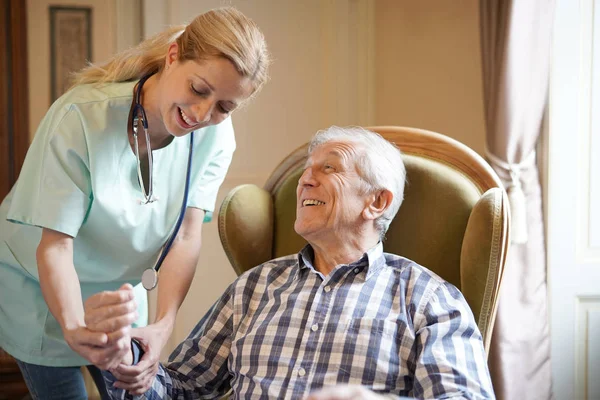 Enfermera revisando hombre mayor — Foto de Stock