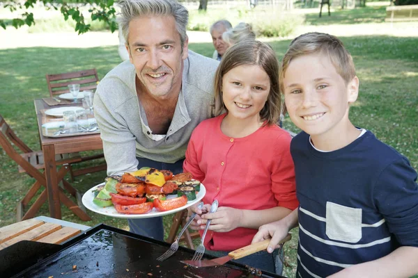 Far med barn förbereder grill — Stockfoto