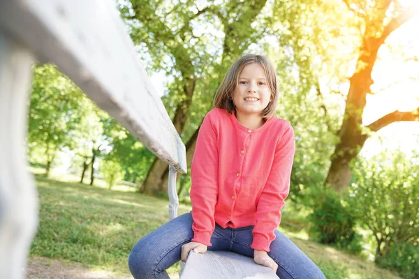 Chica sentado en banco en parque — Foto de Stock