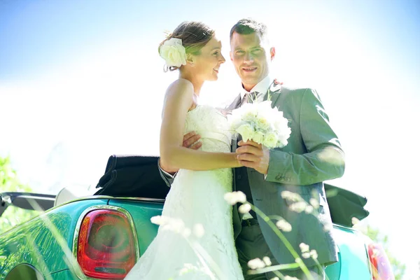 Bride and groom standing by  car — Stock Photo, Image