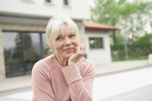 Blond äldre kvinna sitter — Stockfoto