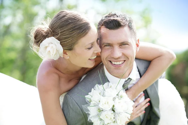 Groom dando passeio de piggyback para noiva — Fotografia de Stock