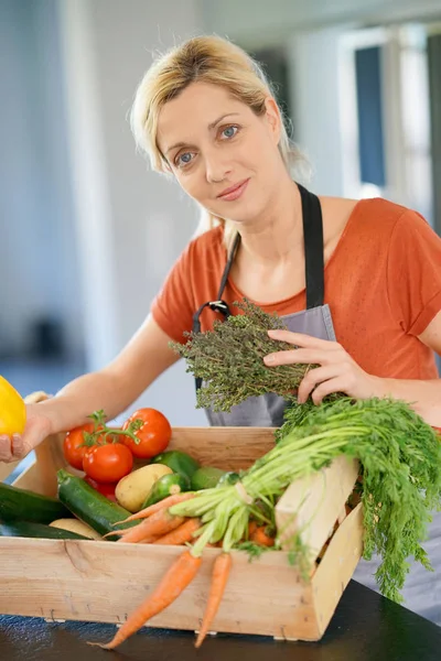 Kvinna i inhemska köket håller korgen — Stockfoto