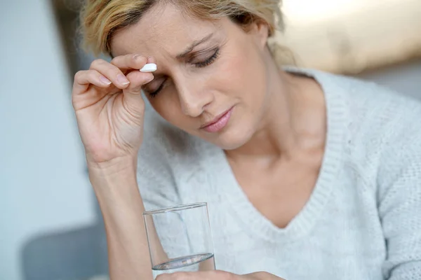 Frau zu Hause nimmt Tablette — Stockfoto