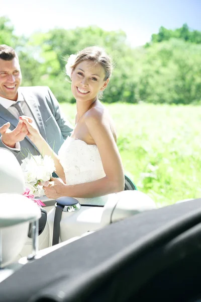 Groom leading bride to get in car — Stock Photo, Image