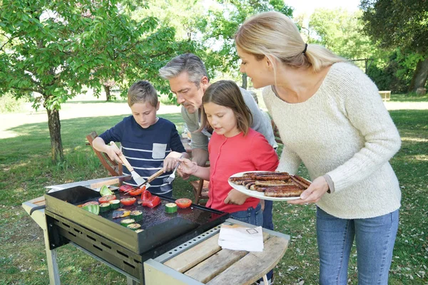 Familia preparando a la parrilla cumplir — Foto de Stock