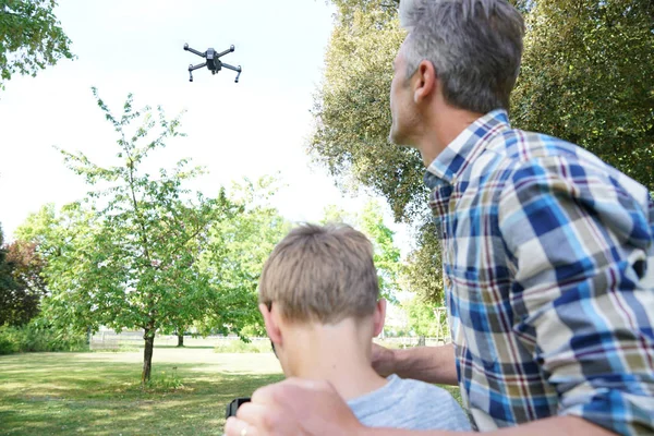 Father and son playing with flying drone — Stock Photo, Image