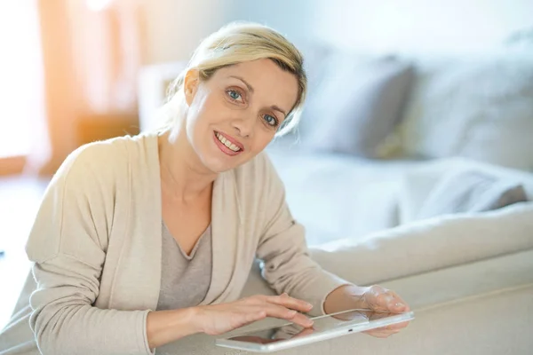 Frau zu Hause mit digitalem Tablet verbunden — Stockfoto