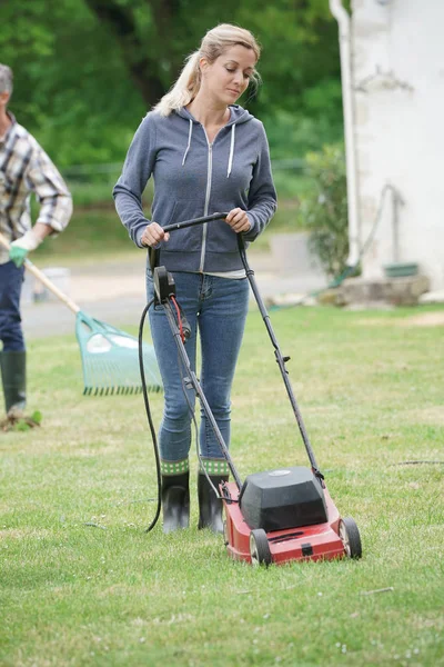 Woman in garden mowing — Stock Photo, Image