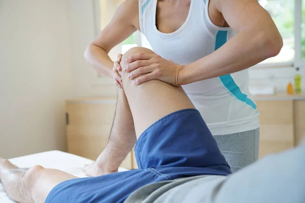 Physiotherapist massaging athlete — Stock Photo, Image