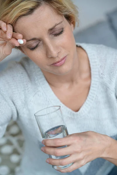 Frau zu Hause nimmt Tablette — Stockfoto