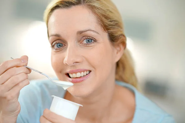 Blond woman eating yogurt — Stock Photo, Image