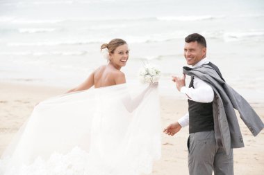  Kumsalda yürüyen çift.