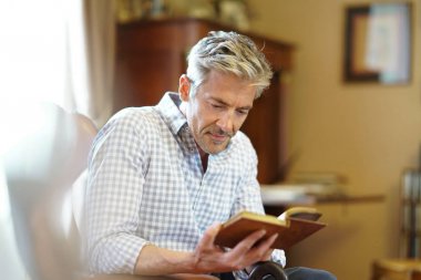 Olgun adam kitap okuyor.