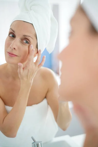 Mujer aplicando crema hidratante —  Fotos de Stock