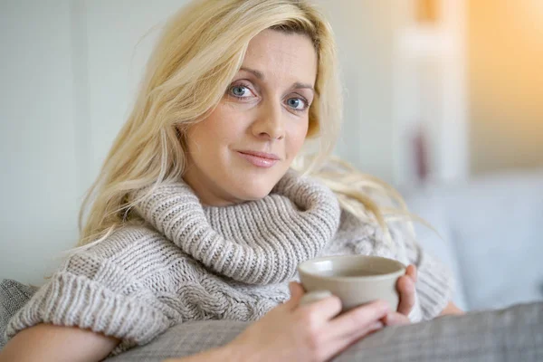 ソファでお茶を飲む女性 — ストック写真
