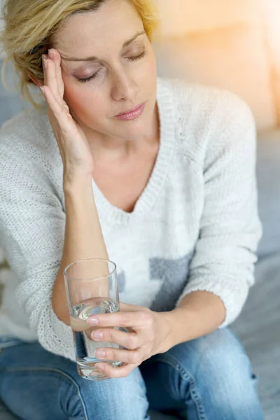 woman at home taking pill
