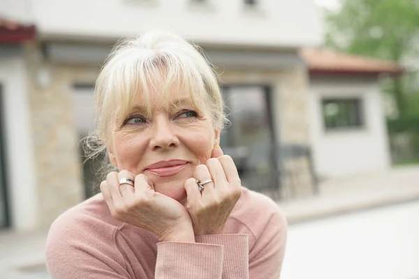 Blond senior vrouw zitten — Stockfoto