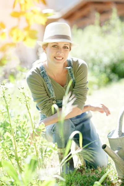 Mujer con sombrero jardinería en el trabajo — Foto de Stock