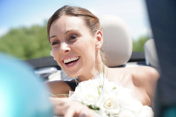 Novia cabalgando en coche descapotable — Foto de Stock