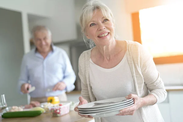 Senior woman laying the table — Stock Photo, Image