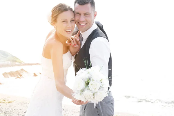 Glückliche Braut und Bräutigam am Strand — Stockfoto