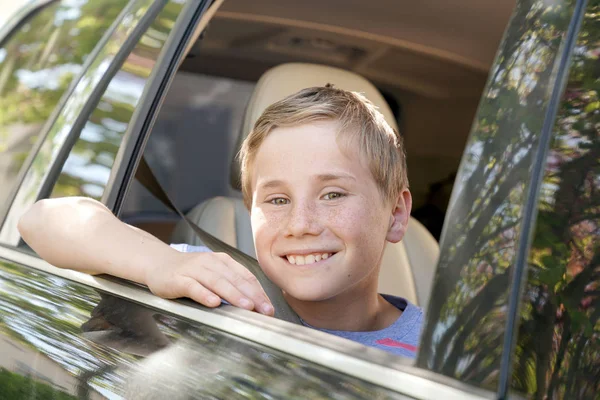 Boy looking by car window — Stock Photo, Image