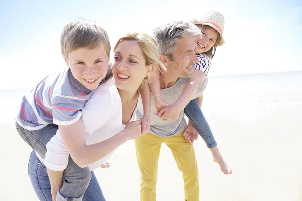 Parents giving piggyback ride to kids