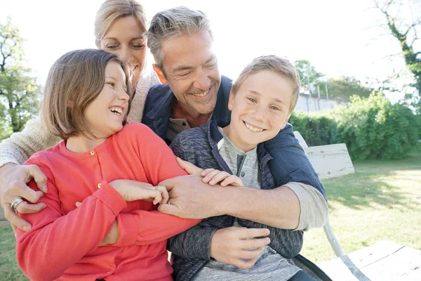 Família de quatro pessoas sentadas no banco — Fotografia de Stock